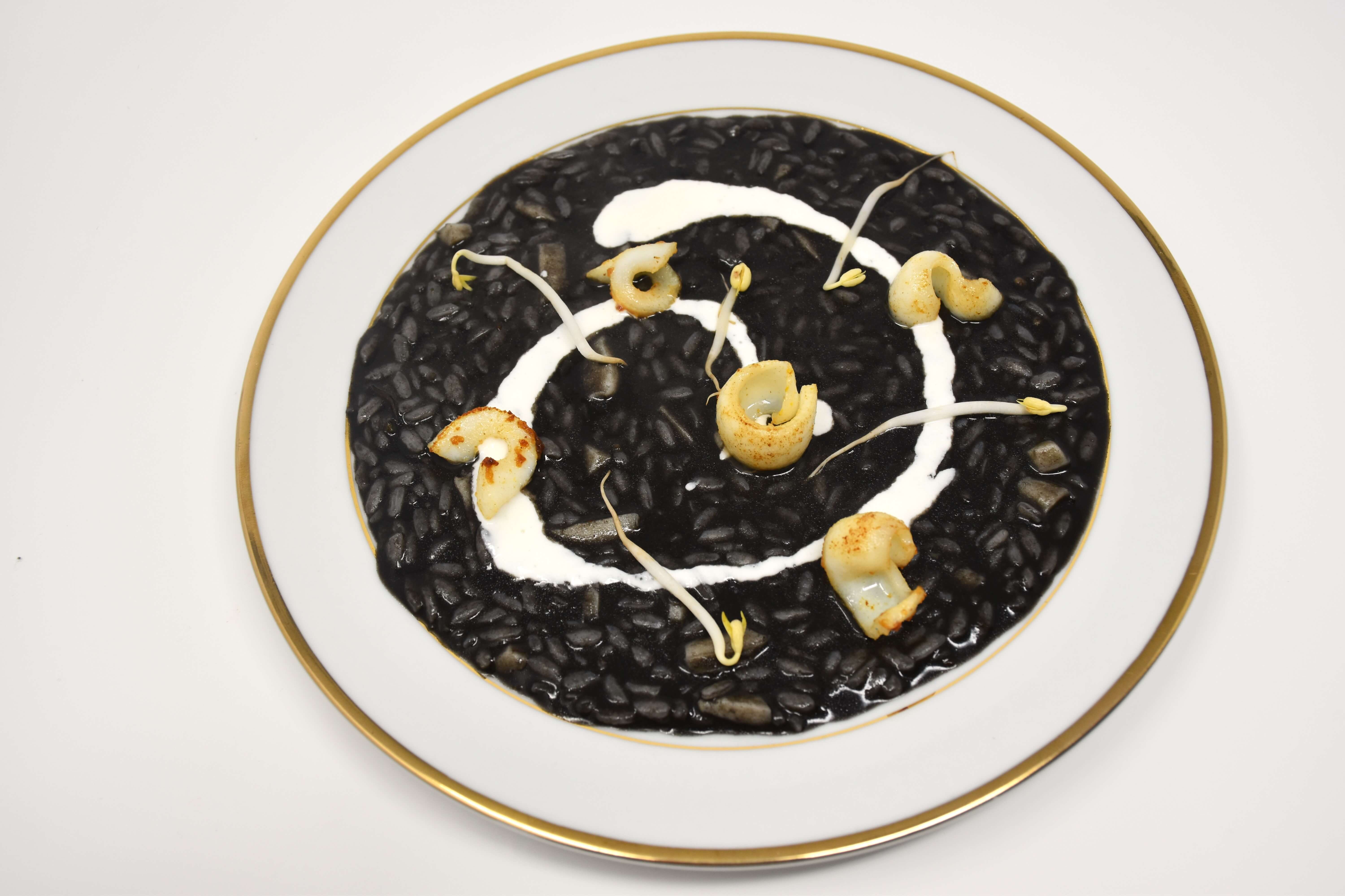 Risotto Carnaroli al nero di seppia mantecato al Parmigiano Reggiano stagionato di 30 mesi, crema di burrata e calamaro croccante