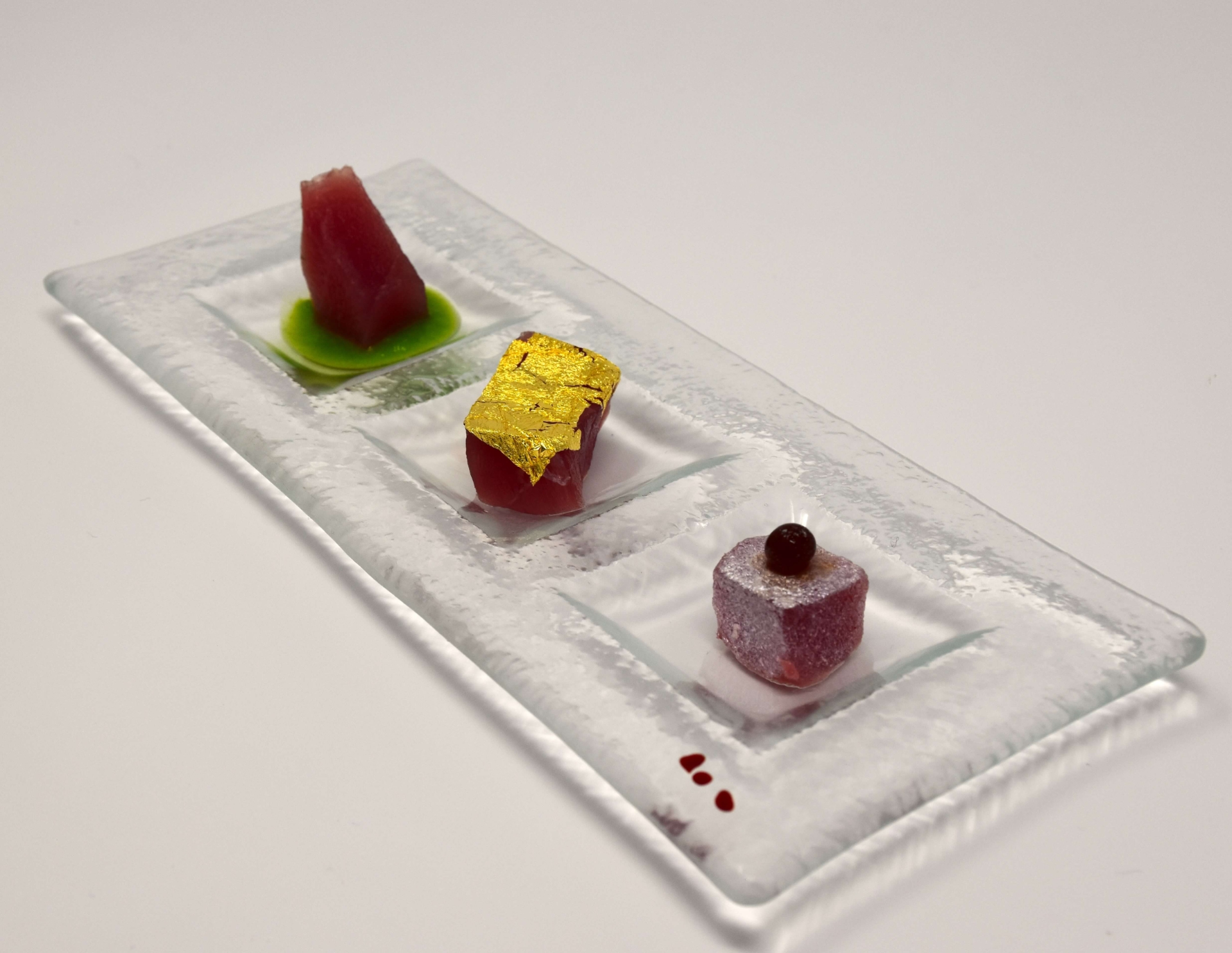 Trittico di tonno. Cubo di tonno con vinaigrette alla menta, tonno con oro edibile e tonno con polvere di sedano